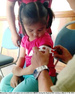 A participant measures a child's mid-upperarm circumference (MUAC) during the Regional NIE Training last March 17-20, 2015.