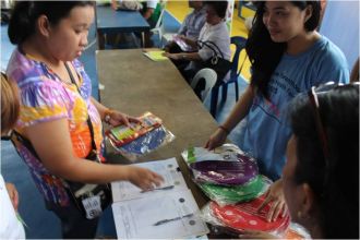 NO II Thesa Rivas giving IEC materials to participants of POPCOM Health Fair
