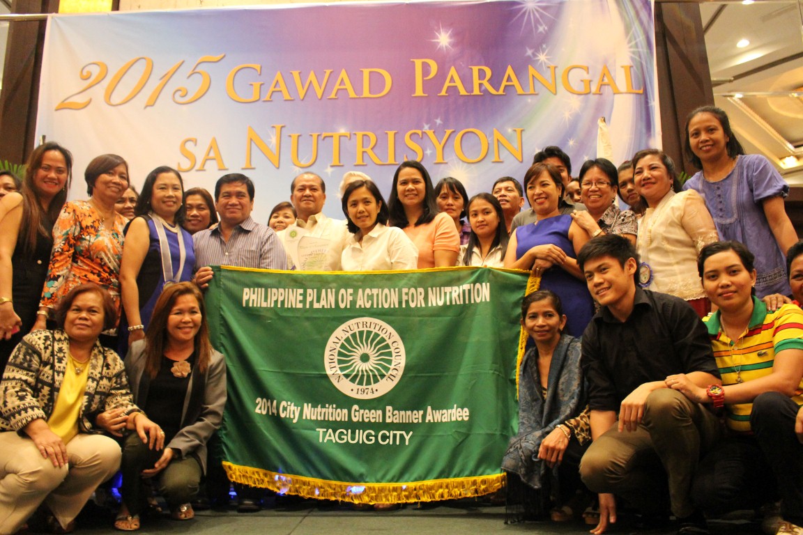 Taguig City receiving their 2014 Green Banner Award with RNPC Milagros Elisa V. Federizo, CNAO Julie Bernabe, City Nutrition Committee members and Barangay Nutrition Scholars