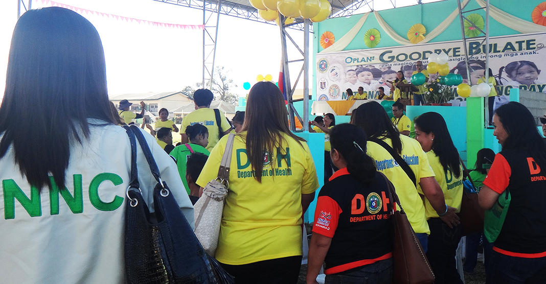 NO I Caballero looks over to the school children of Nabunturan Central Elementary School with some of the DOH XI Staff